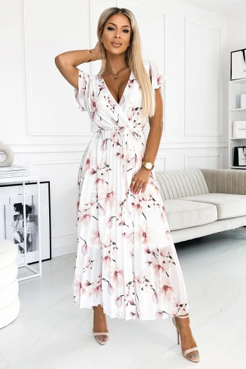 Modelka prezentuje elegancką sukienkę w kwiaty, która idealnie podkreśla kobiecą sylwetkę. Ta sukienka w kwiaty to doskonały wybór na letnie przyjęcia, łącząc w sobie styl i wygodę.