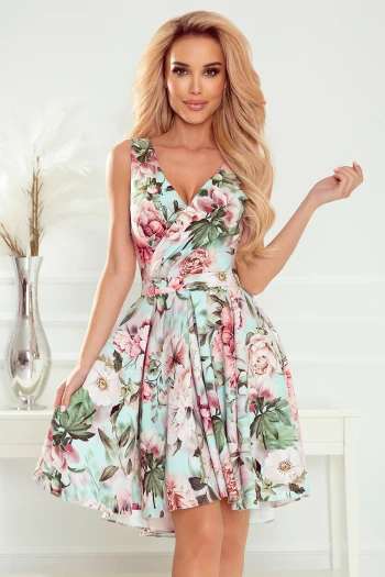 Modelka prezentuje elegancką sukienkę w kwiaty, która zachwyca swoim romantycznym wzorem i delikatnymi pastelowymi kolorami. Ta kwiecista sukienka podkreśla kobiecą sylwetkę, dodając jej subtelnego uroku i wdzięku.