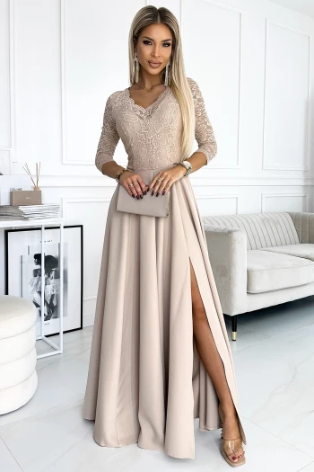 Kobieta na zdjęciu prezentuje elegancką sukienkę wieczorową z koronkową górą i rozkloszowanym dołem, która idealnie podkreśla sylwetkę. Sukienka wieczorowa z subtelnym rozcięciem dodaje stylizacji wyrafinowanego charakteru, idealnego na wyjątkowe okazje.