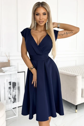 Modelka prezentuje elegancką sukienkę kopertową, która podkreśla sylwetkę i dodaje klasy każdej stylizacji. Sukienka kopertowa w głębokim granatowym kolorze jest idealnym wyborem na wieczorne wyjścia i formalne okazje.