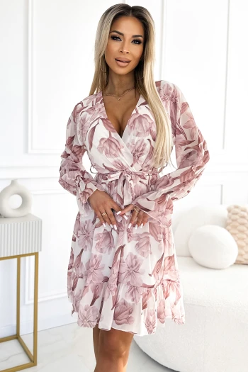 Modelka prezentuje elegancką sukienkę w kwiaty, która idealnie podkreśla kobiecą sylwetkę. Sukienka w kwiaty z delikatnym wiązaniem w talii dodaje stylizacji lekkości i romantycznego uroku.