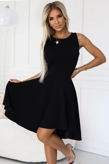 Kobieta na zdjęciu prezentuje elegancką czarną sukienkę, która doskonale podkreśla jej sylwetkę. Ta klasyczna mała czarna sukienka to idealny wybór na wieczorne wyjścia, łącząc w sobie styl i ponadczasową elegancję.