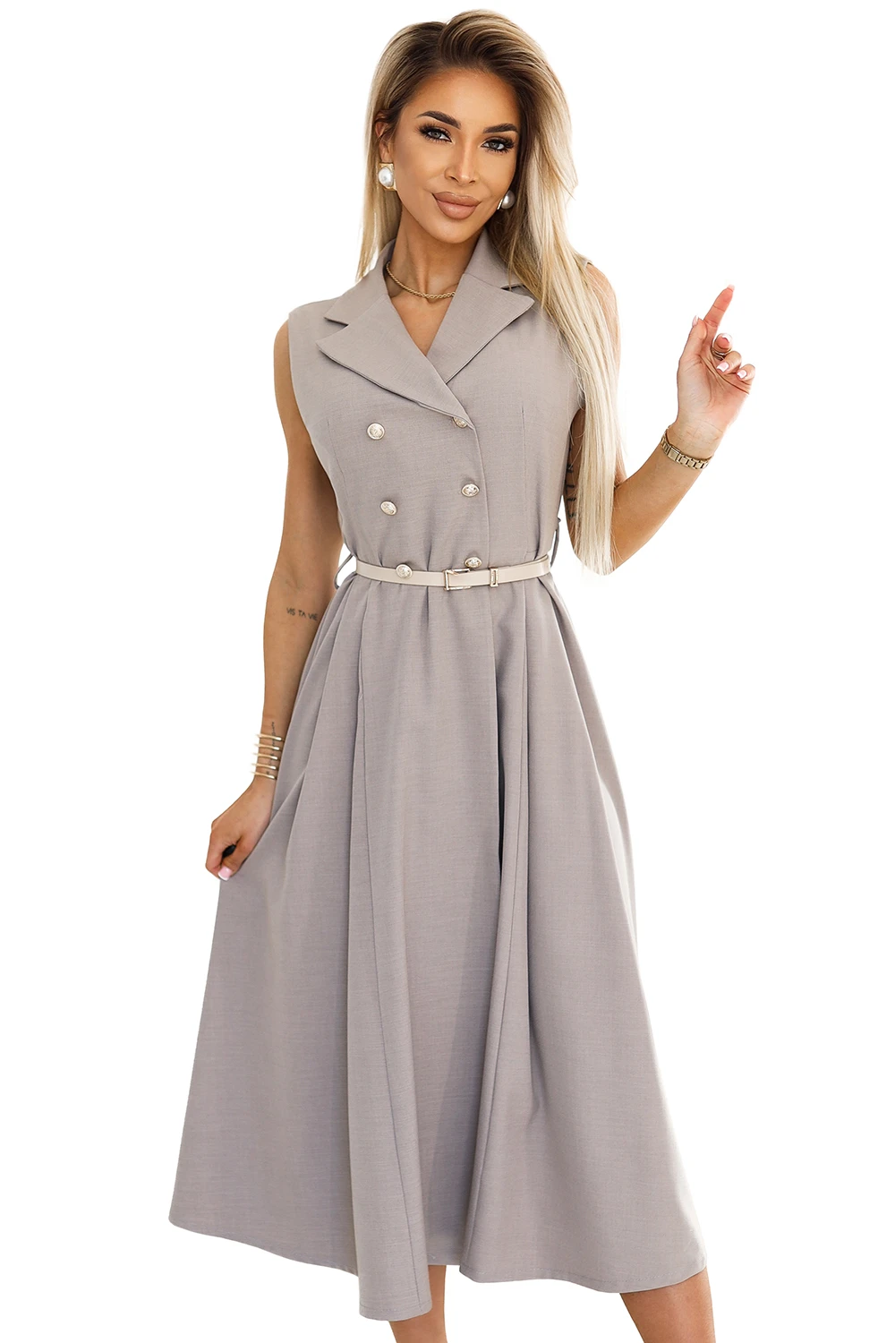 Modelka prezentuje elegancką sukienkę midi z kołnierzem, która idealnie podkreśla sylwetkę dzięki dopasowanemu paskowi. Ta stylowa sukienka midi z kołnierzem jest doskonałym wyborem na formalne okazje, łącząc klasykę z nowoczesnym designem.