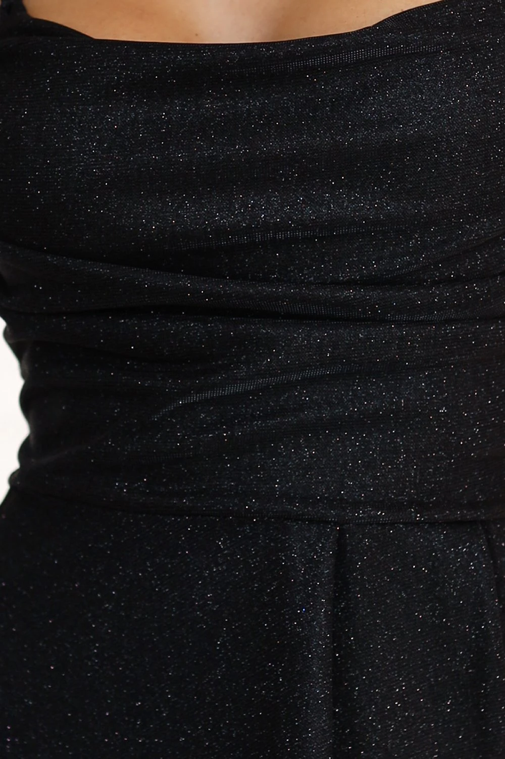 Modelka prezentuje elegancką sukienkę z połyskującego materiału, która idealnie podkreśla sylwetkę. Sukienka z połyskiem dodaje szyku i jest doskonałym wyborem na wieczorne wyjścia.