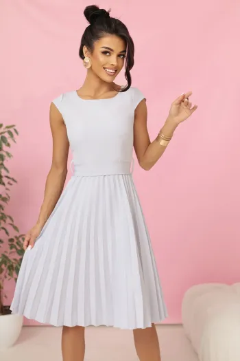 Modelka prezentuje elegancką sukienkę midi z plisowanym dołem, która idealnie podkreśla kobiecą sylwetkę. Ta sukienka midi to doskonały wybór na wyjątkowe okazje, łącząc klasyczny styl z nowoczesnym wykończeniem.