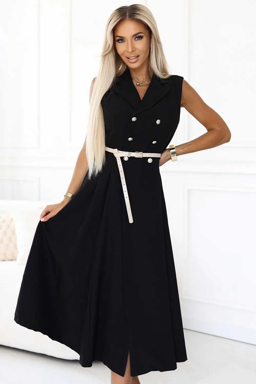 Kobieta na zdjęciu prezentuje elegancką sukienkę midi z kołnierzykiem, która idealnie podkreśla sylwetkę dzięki subtelnemu paskowi w talii. Sukienka midi z kołnierzykiem wyróżnia się klasycznym krojem i ponadczasowym stylem, idealnym na każdą okazję.