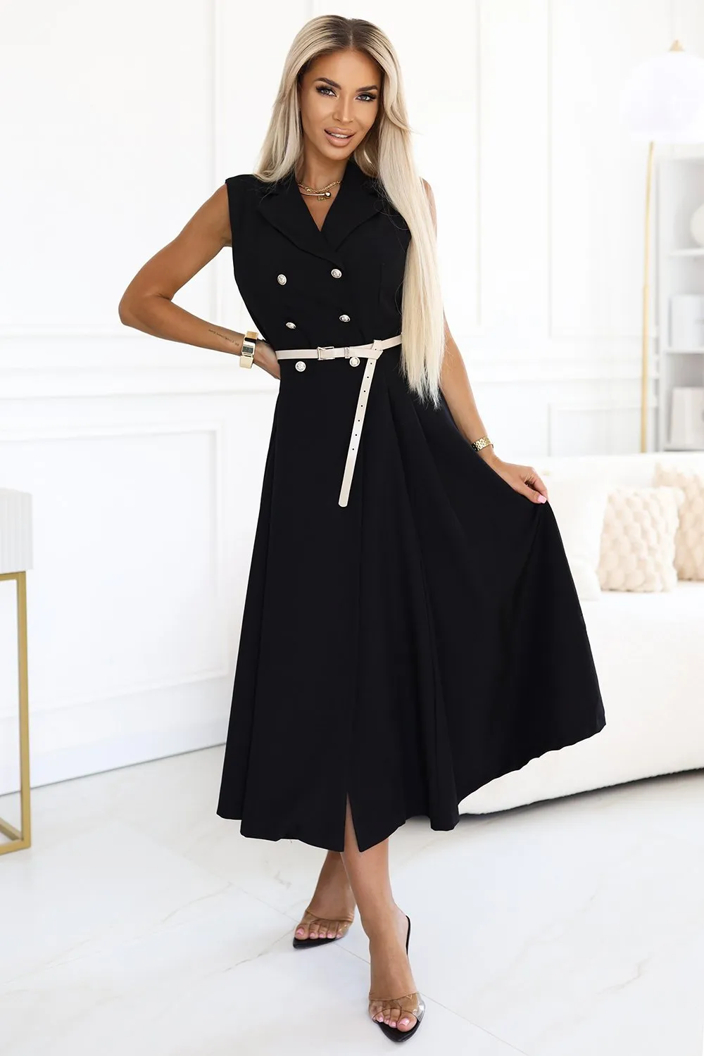 Kobieta na zdjęciu prezentuje elegancką sukienkę midi z podwójnym rzędem guzików, która idealnie podkreśla jej sylwetkę. Sukienka midi z podwójnym rzędem guzików wyróżnia się klasycznym krojem i stylowym paskiem w talii, dodającym całości szyku.