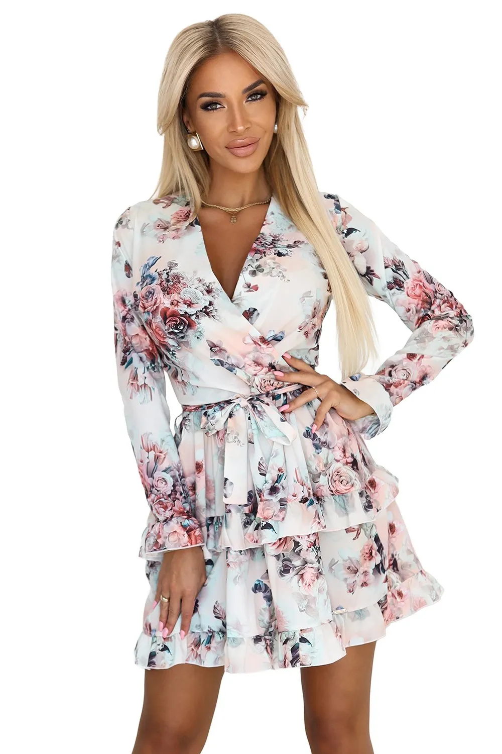 Modelka prezentuje elegancką sukienkę w kwiaty, która zachwyca delikatnym wzorem i kobiecym krojem. Sukienka w kwiaty podkreśla sylwetkę, a falbany dodają jej lekkości i romantycznego charakteru.