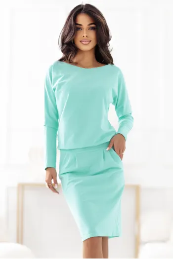 Modelka prezentuje elegancką sukienkę dresową w odcieniu mięty, która łączy w sobie wygodę i styl. Sukienka dresowa idealnie podkreśla sylwetkę, a jej miękki materiał zapewnia komfort noszenia na co dzień.