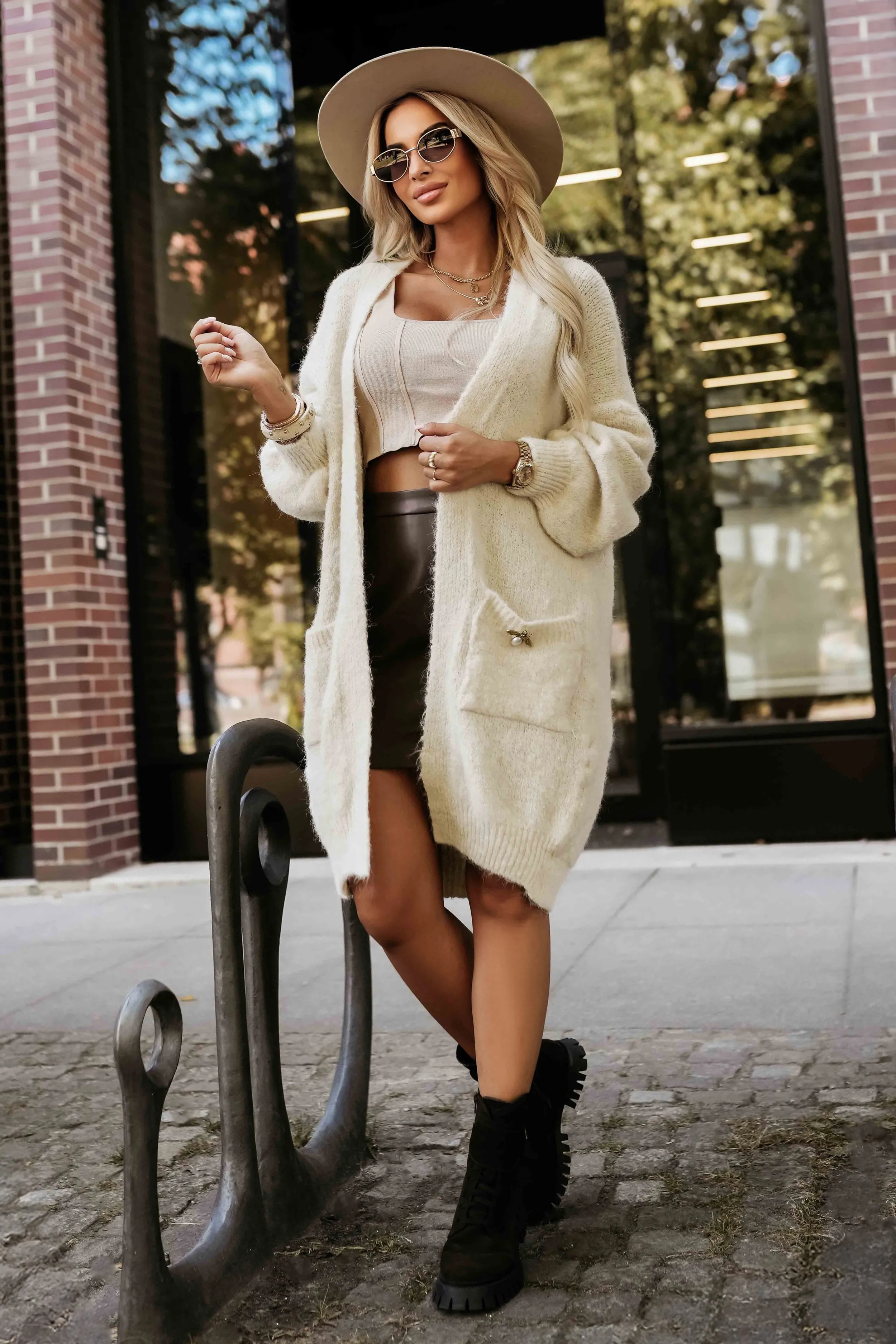 Modelka prezentuje elegancki kardigan z kieszeniami, który idealnie komponuje się z casualowym stylem. Ten kardigan z kieszeniami dodaje stylizacji przytulności i modnego wyglądu.