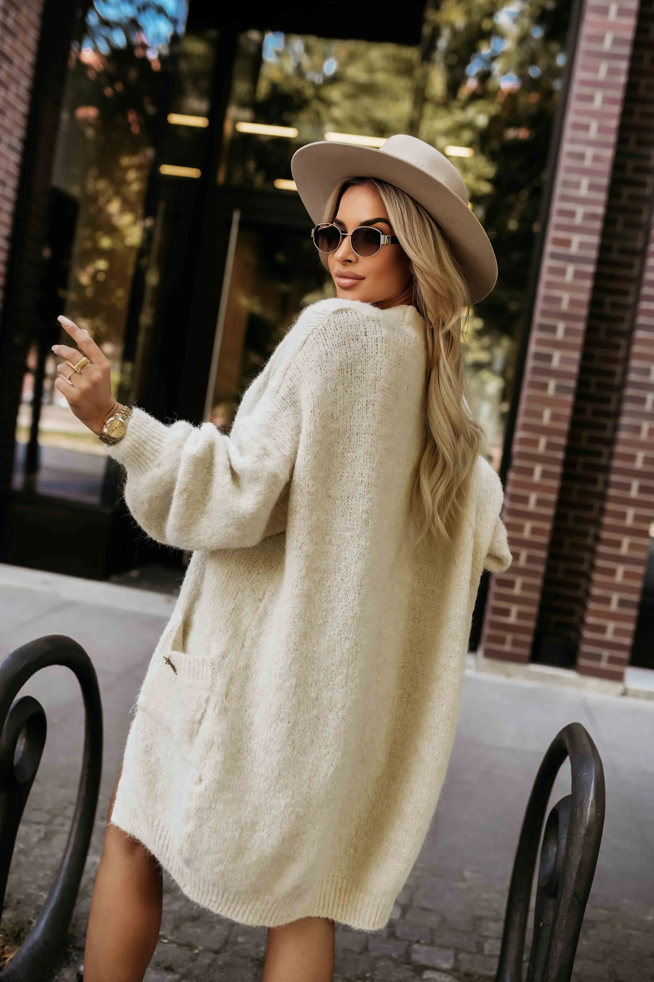 Kobieta na zdjęciu prezentuje stylowy kardigan oversize, który idealnie wpisuje się w jesienne trendy. Miękki kardigan oversize dodaje elegancji i zapewnia komfort w chłodniejsze dni.